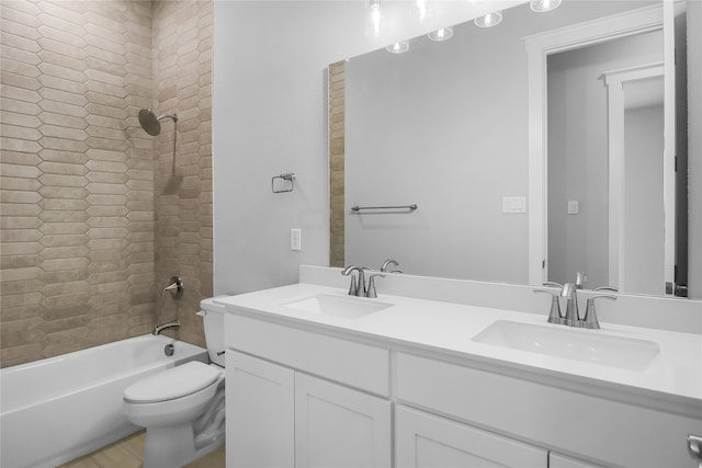 full bathroom featuring tiled shower / bath, vanity, and toilet