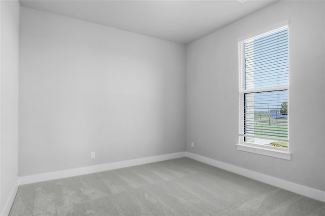 spare room featuring light colored carpet and a healthy amount of sunlight