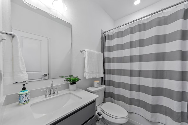 bathroom with curtained shower, vanity, and toilet