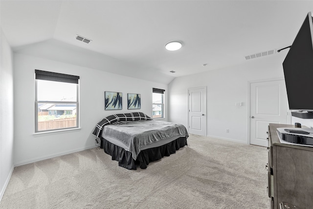 bedroom with lofted ceiling and light carpet