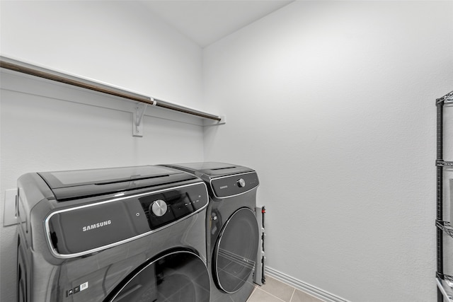 laundry room with light tile patterned flooring and washing machine and clothes dryer