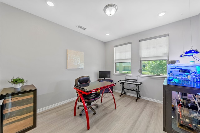 home office with wine cooler and light wood-type flooring