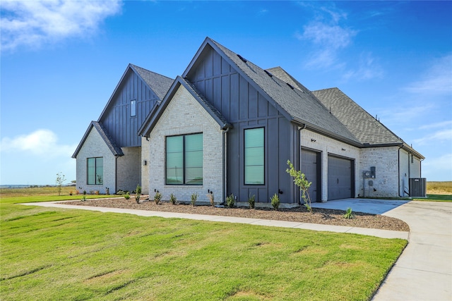 modern inspired farmhouse with a front yard and central air condition unit