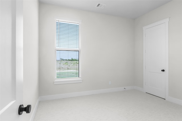 unfurnished room featuring a wealth of natural light and light colored carpet