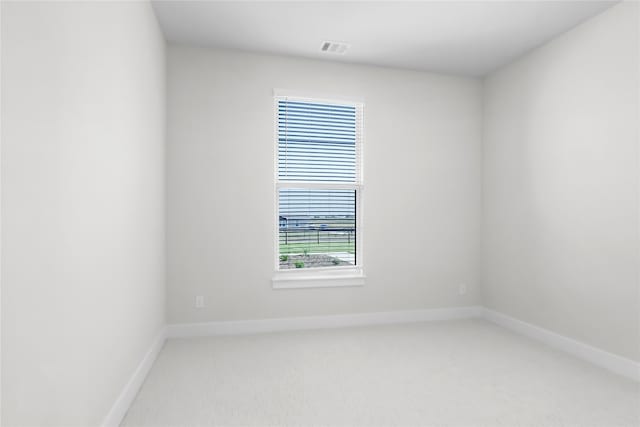 empty room featuring light colored carpet and a wealth of natural light