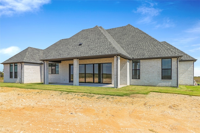 rear view of house featuring a yard and a patio area