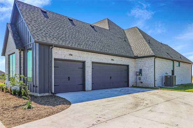 view of side of home featuring central AC and a garage