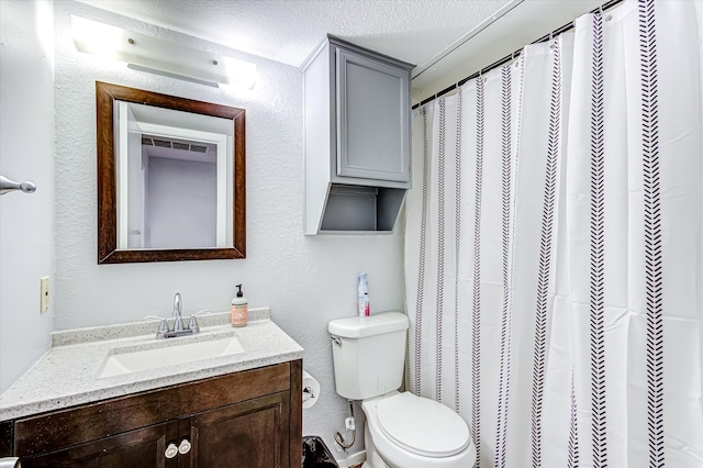 bathroom with a textured ceiling, toilet, vanity, and curtained shower