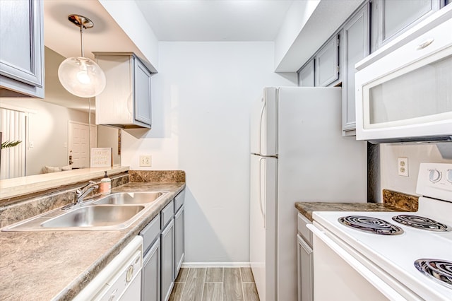 kitchen with gray cabinetry, light tile patterned floors, sink, decorative light fixtures, and white appliances