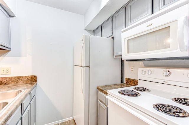 kitchen with sink, white appliances, and gray cabinets