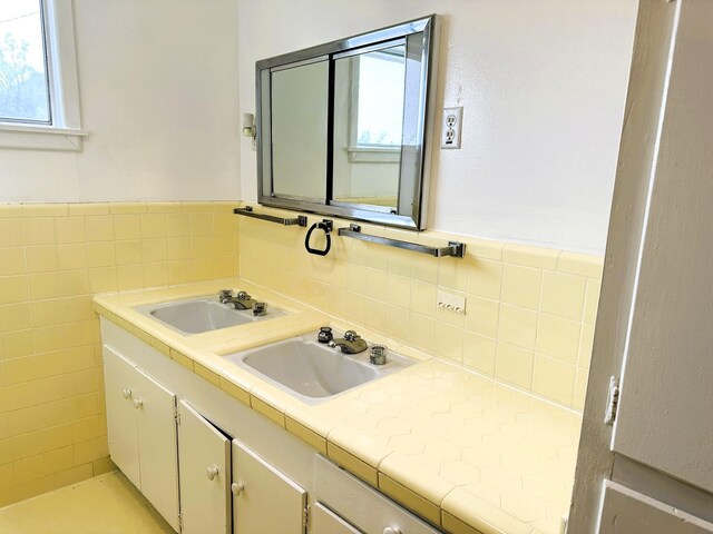 bathroom featuring tasteful backsplash, vanity, and tile walls