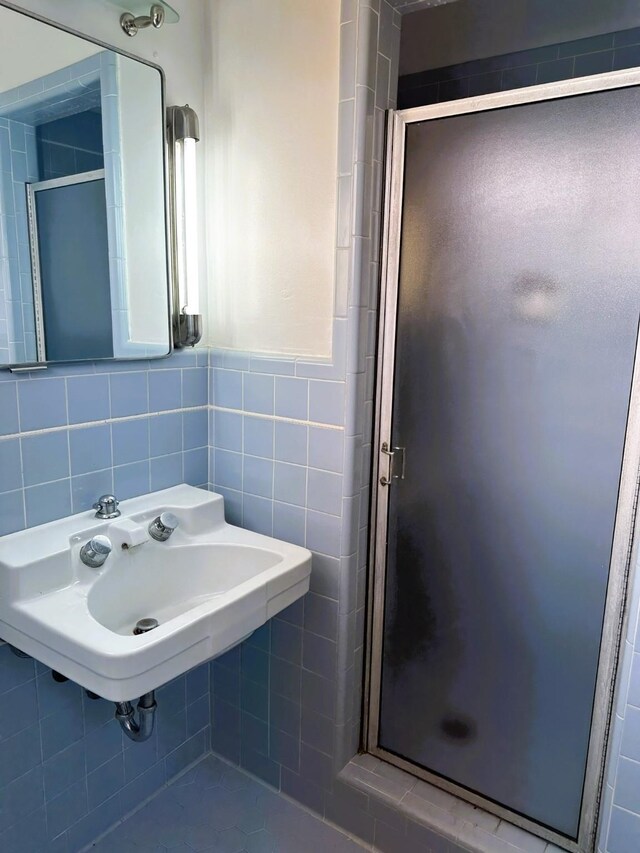 bathroom featuring tile walls, sink, and walk in shower