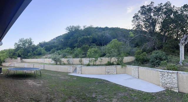 view of yard featuring a trampoline and fence