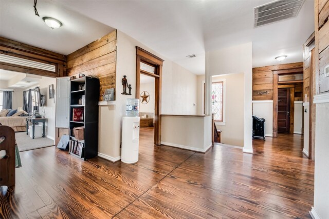 interior space with open floor plan, wood finished floors, visible vents, and baseboards
