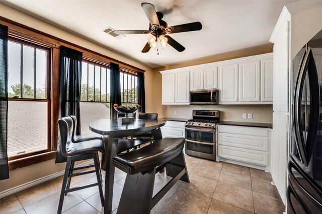 kitchen featuring visible vents, white cabinets, baseboards, dark countertops, and appliances with stainless steel finishes