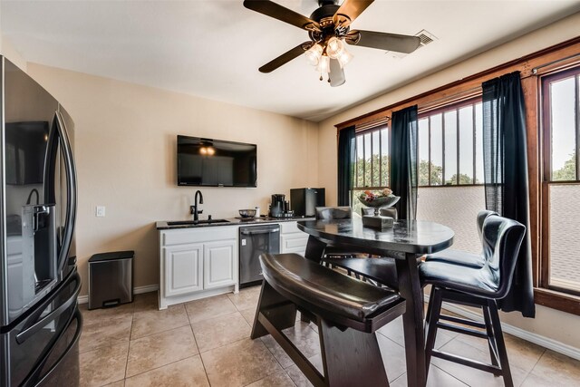 dining room with light tile patterned floors, ceiling fan, arched walkways, and baseboards