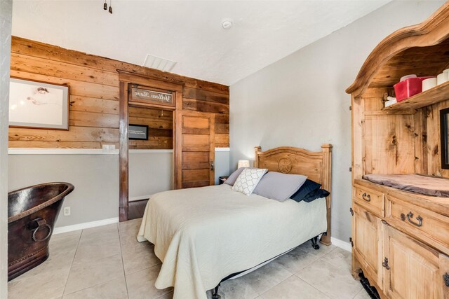 bedroom featuring light tile patterned floors and baseboards