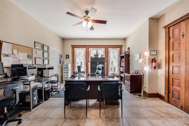 office area featuring ceiling fan, baseboards, and light tile patterned floors