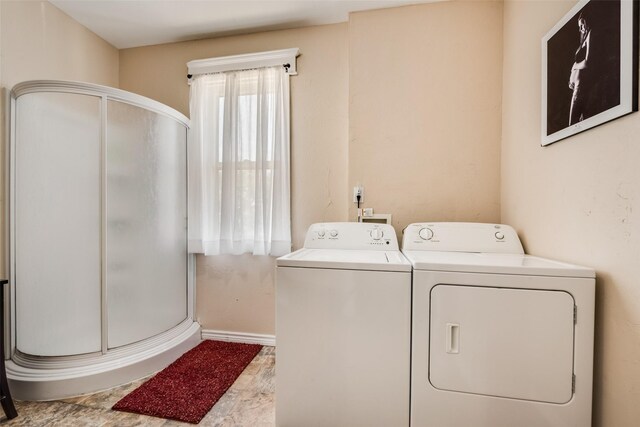laundry room featuring laundry area, baseboards, and washing machine and clothes dryer