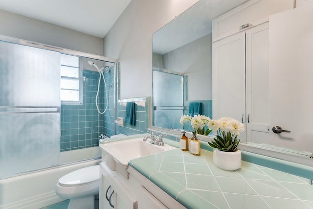 full bathroom with shower / bath combination with glass door, vanity, and toilet