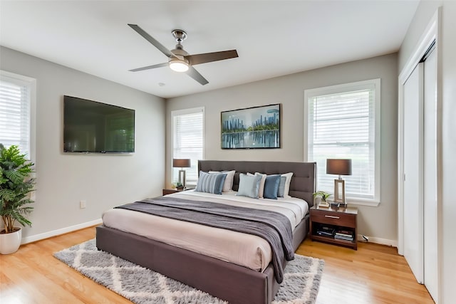 bedroom featuring light hardwood / wood-style floors, multiple windows, and ceiling fan