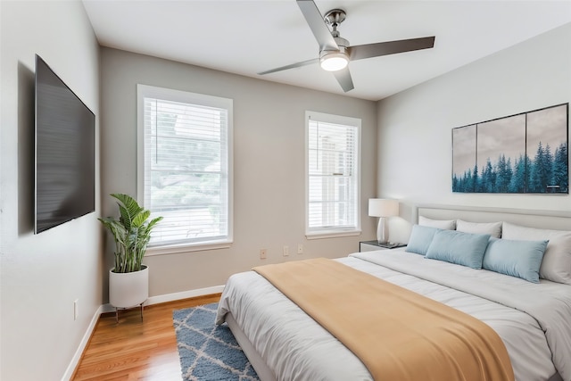 bedroom featuring wood-type flooring, multiple windows, and ceiling fan