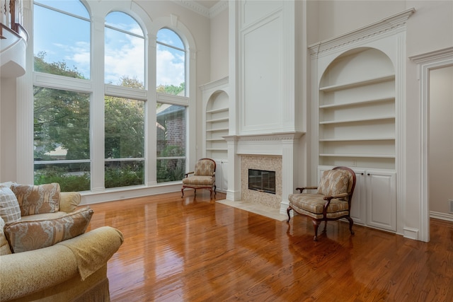 living room featuring wood-type flooring, plenty of natural light, and built in features