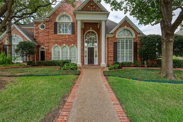 view of front of property featuring a front lawn and brick siding