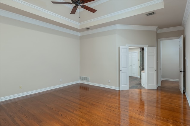 unfurnished bedroom with ceiling fan, crown molding, wood-type flooring, and a tray ceiling