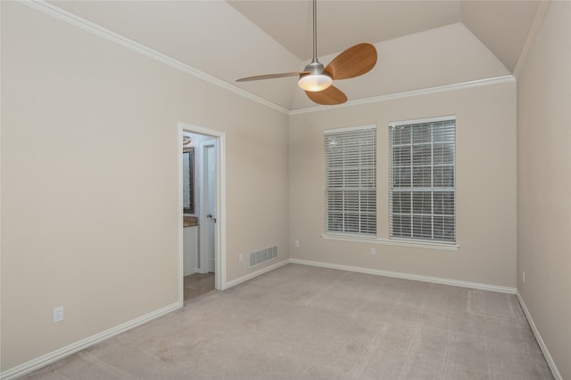 carpeted spare room featuring ceiling fan, vaulted ceiling, and crown molding