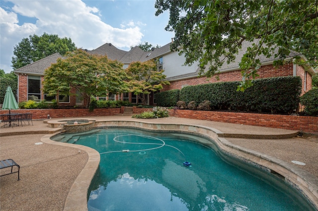 view of swimming pool featuring an in ground hot tub and a patio