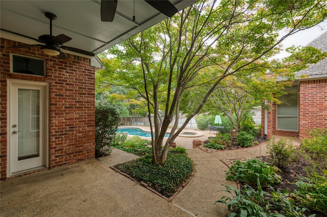 view of patio / terrace featuring ceiling fan and a fenced in pool