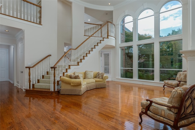 living room featuring a wealth of natural light, crown molding, and wood-type flooring