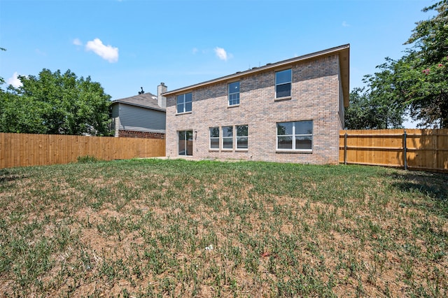 rear view of property featuring a lawn