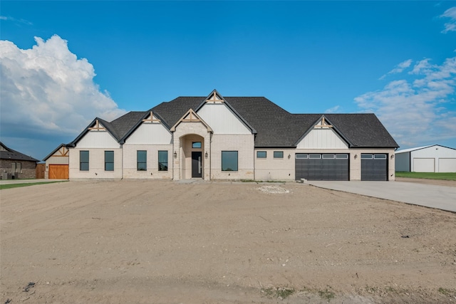 view of front of property with brick siding, a shingled roof, an attached garage, board and batten siding, and driveway