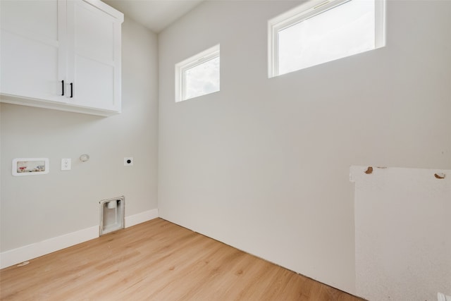 washroom featuring washer hookup, cabinets, hookup for an electric dryer, light hardwood / wood-style floors, and gas dryer hookup