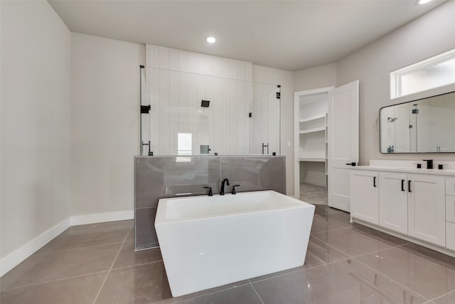 bathroom with plus walk in shower, tile patterned flooring, and vanity