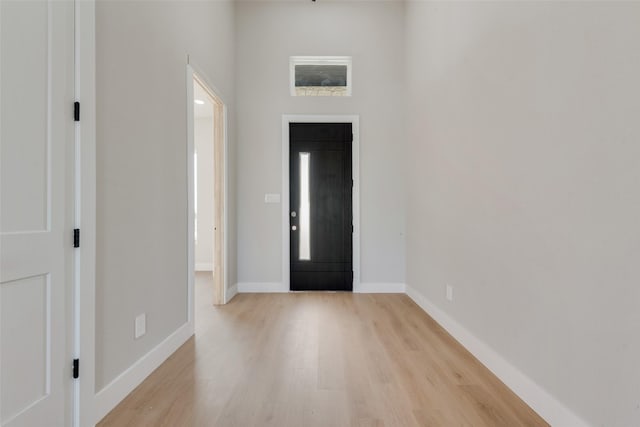 foyer with light wood-style floors and baseboards