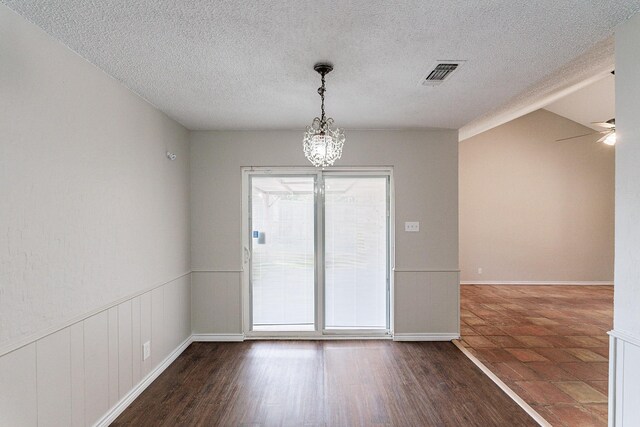 unfurnished room with a textured ceiling, dark tile patterned floors, and ceiling fan with notable chandelier