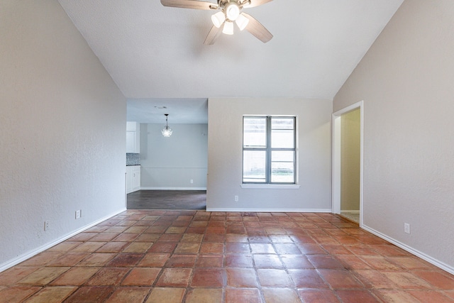 spare room featuring dark tile patterned flooring, ceiling fan, and lofted ceiling