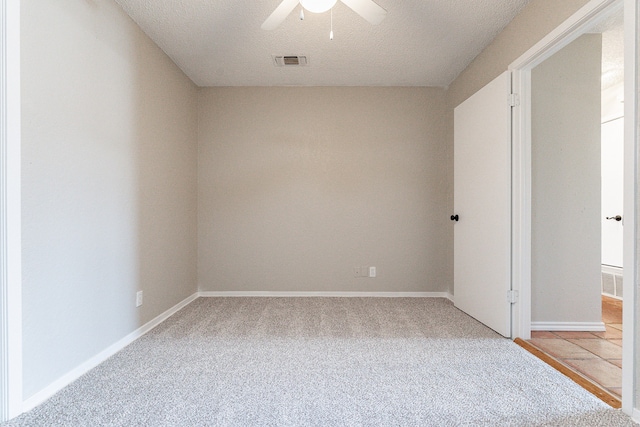 unfurnished bedroom with ceiling fan, a textured ceiling, and light carpet