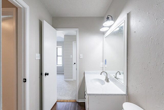 bathroom featuring toilet, a textured ceiling, vanity, and wood-type flooring