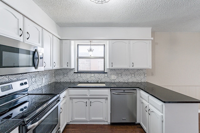 kitchen with white cabinetry, appliances with stainless steel finishes, dark hardwood / wood-style floors, and backsplash