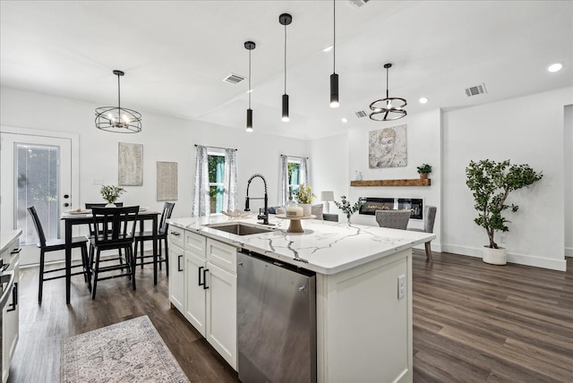 kitchen featuring pendant lighting, an island with sink, dark wood-type flooring, stainless steel dishwasher, and white cabinets