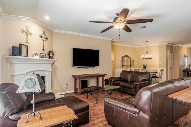 living room with ornamental molding, ceiling fan with notable chandelier, and wood-type flooring