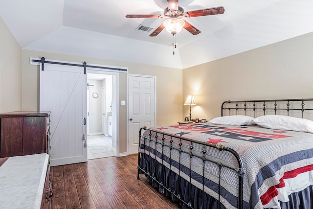 bedroom featuring a raised ceiling, dark hardwood / wood-style flooring, lofted ceiling, a barn door, and ceiling fan