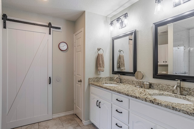 bathroom with tile patterned flooring, vanity, and a textured ceiling