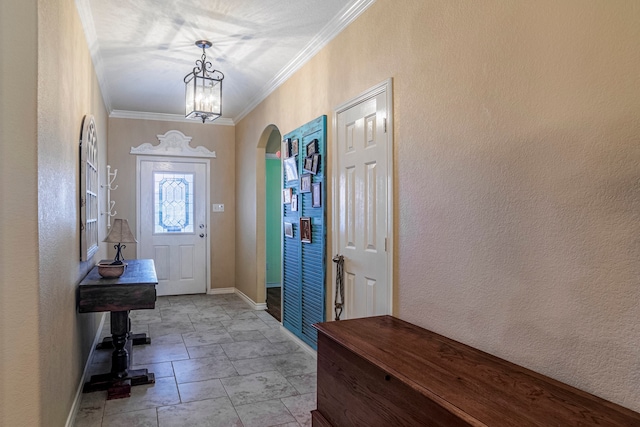 tiled foyer entrance featuring ornamental molding and an inviting chandelier