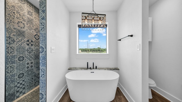 bathroom with shower with separate bathtub, toilet, wood-type flooring, and a chandelier