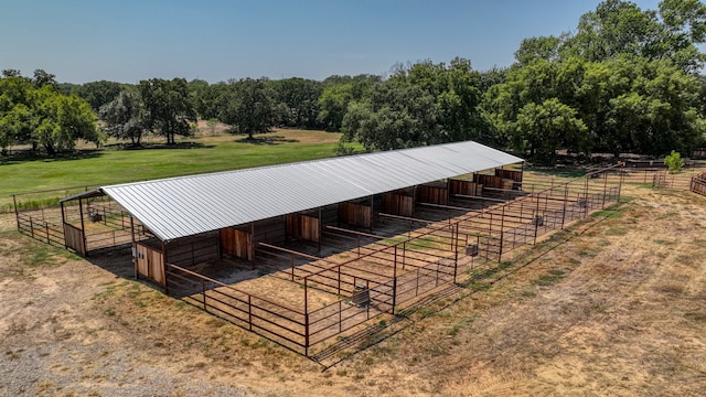 view of horse barn featuring an outbuilding and a rural view